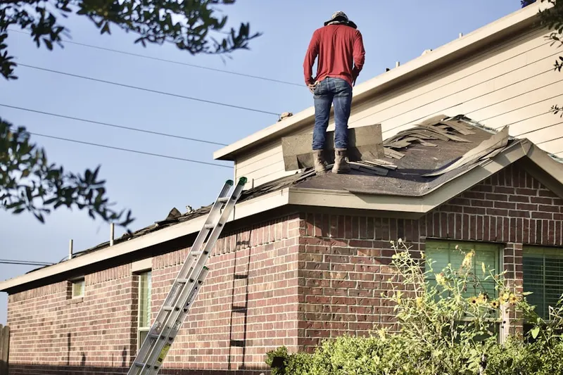 Professional roofer working on a residential roof in Ellendale Forge